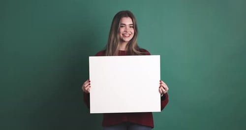 Smiling Woman Holding Blank Sign Against Teal Background