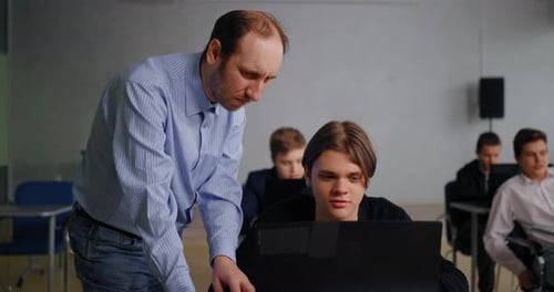 Teacher And Student Teen Boy In ComputerBased Classroom Education And Learning In Middle School