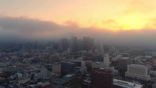 Serene aerial view of a foggy Los Angeles skyline at golden hour