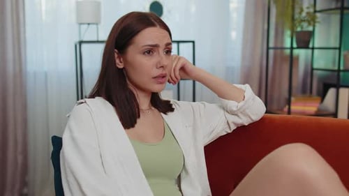 Sad Woman Sitting on Sofa Indoors During Daytime