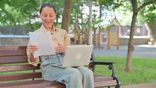 Woman Using Laptop on Bench in Green Park