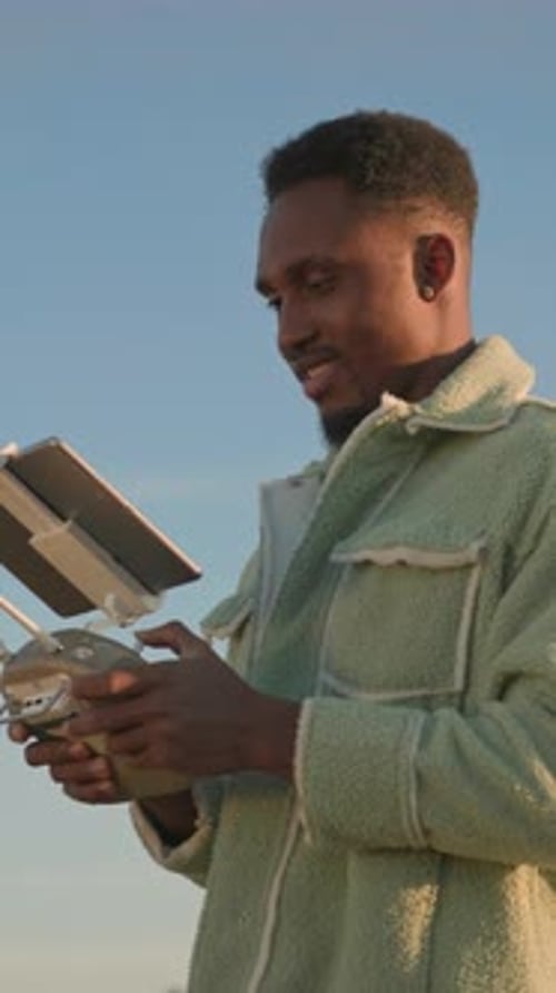 African American Harvest Expert with Tablet Controller Flying Futuristic Drone in Field Copter