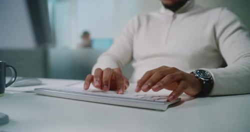 Close Up of African American Ecommerce Manager Typing on Keyboard Chatting with Client Using PC