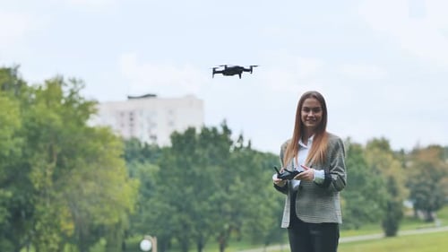 Ein süßes Mädchen kontrolliert eine Drohne im Park