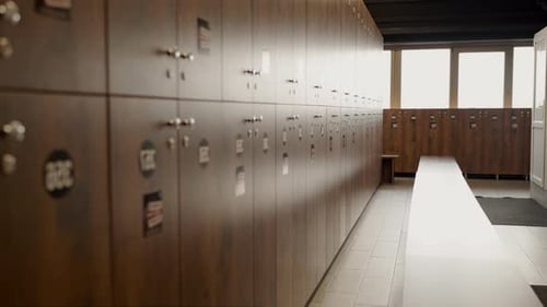 Vestuarios de gimnasio vacíos con hileras de casilleros de madera