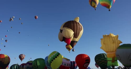 Happy puppy head hot air balloon floating over a row of colorful balloons with ascending balloons in