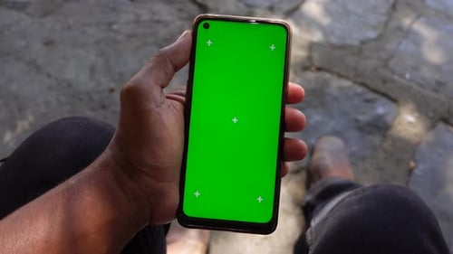 Hand Holding Smartphone with Green Screen Displayed