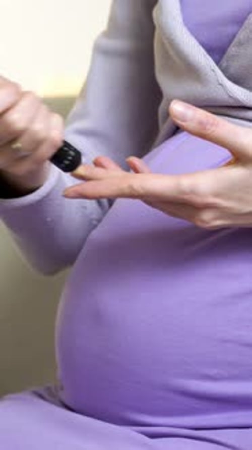 Pregnant Woman Pricking Finger to Test Blood Sugar