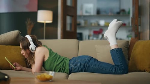 Young Woman Lying on Couch with Phone