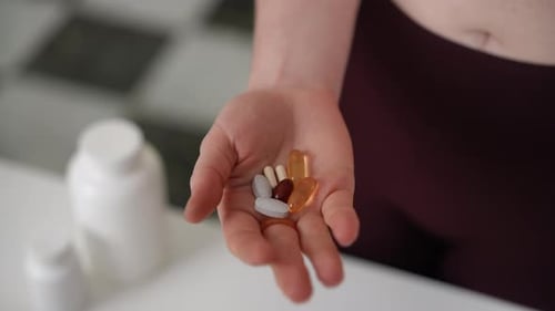 A Closeup View Showcasing a Variety of Dietary Supplements Being Held Emphasizing Health and Overall