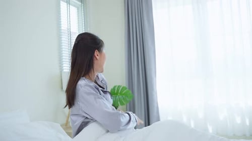 Woman Wakes Up and Stretches in Bedroom