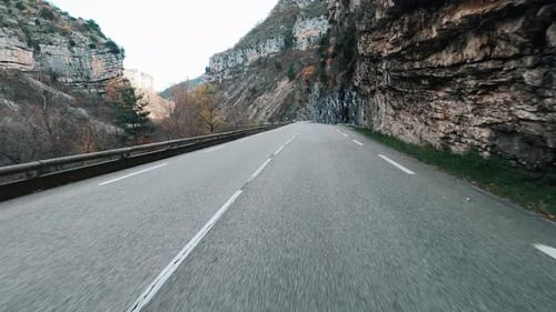 Lange leere Straße und Autoperspektive mit Bergen auf beiden Seiten. Reisen an einem malerischen Ort
