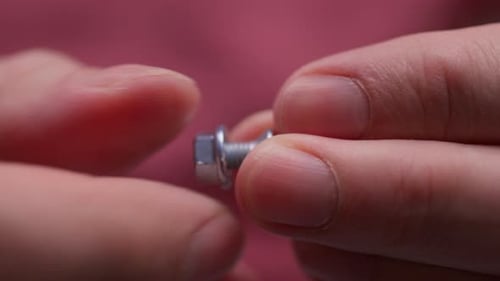 Man's Hands Assembling a Bolt Screw Macro Shot