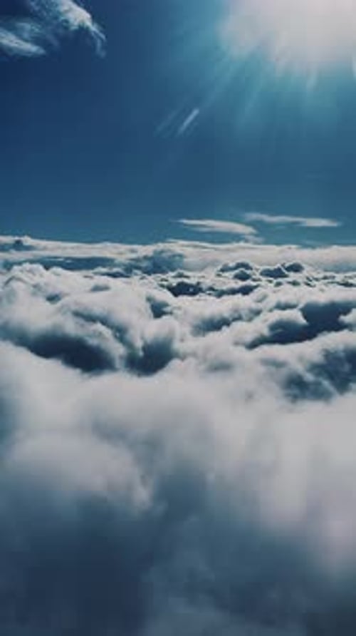 Bright Rays Of The Sun In The Blue Sky Above The Clouds. Vertical Format