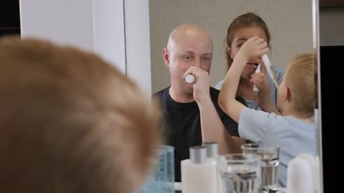A Family in the Morning in the Bathroom They Brush Their Teeth Together