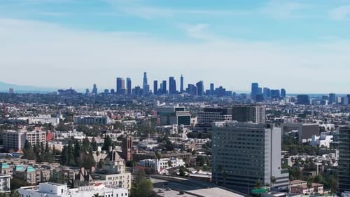 Telephoto drone shot of the los angeles skyline during a sunny day panning left