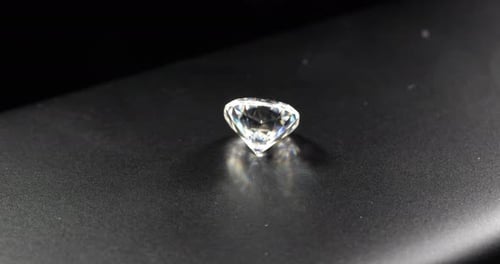 Sparkling Gemstone Rotating on Dark Surface