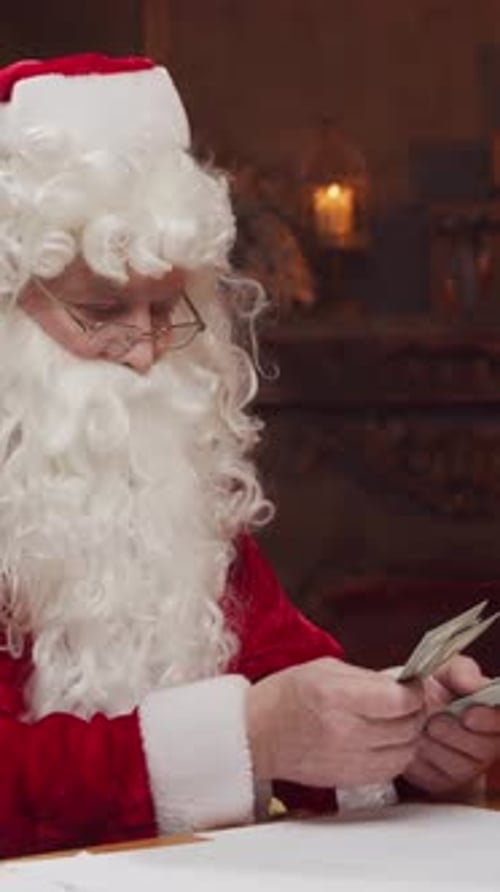 Santa Claus's Workshop Santa is Busy Wrapping a Gift at the Table with a Fireplace and Christmas