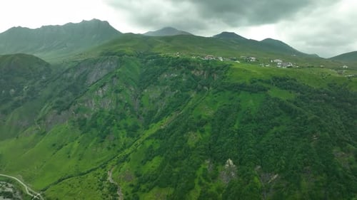 Steep Green Mountain Slopes under Cloudy Sky