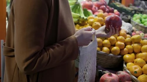Healthy Eating Nutrition and Diet Concept Choosing Pomegranate at Fruit Vegetable in Grocery Store