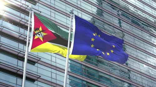 Mozambique and European Union Flags Waving Against Modern Building