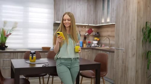 Woman using smartphone in a kitchen setting