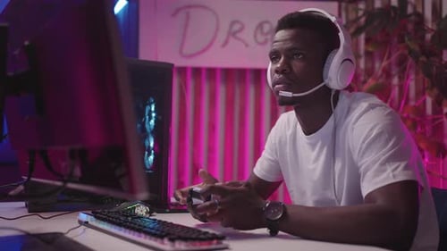 Focused Young Adult Playing Video Games at Desk