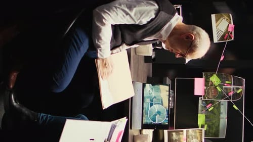 Investigator Sitting at Desk Looking at Evidence