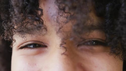 Portrait close up of the eyes of happy african american teenage girl smiling, slow motion