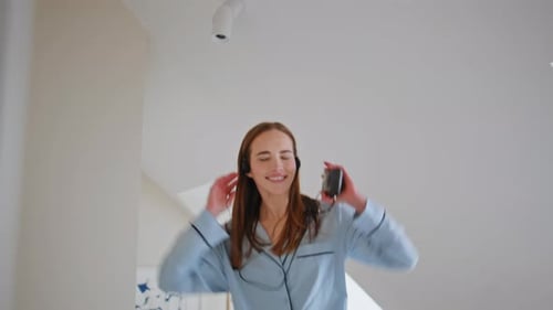 Woman Dancing Joyfully in Bedroom with Cassette Player