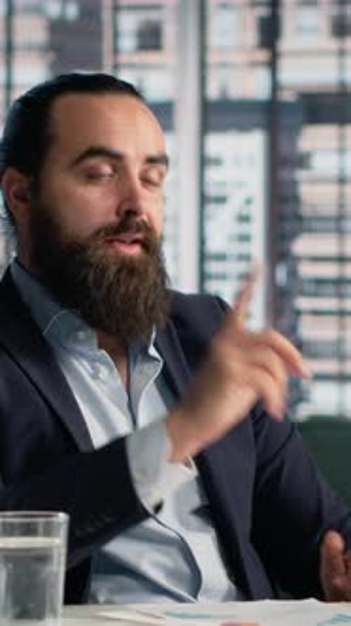 Bearded Man in Suit Speaking in Office