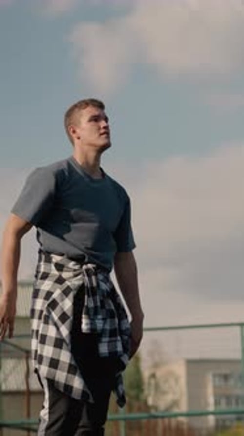 Man Hits Volleyball Over Net on Outdoor Court