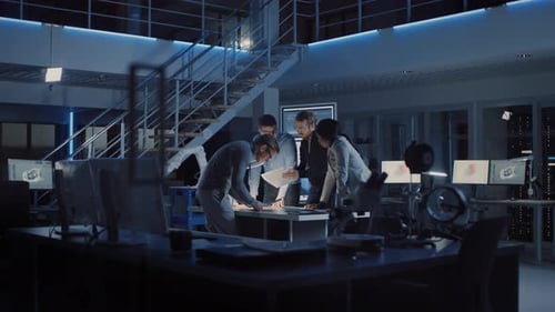 Team Collaborates Over Blueprints in Modern Office