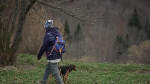Woman Walks with Dog in Mountainous Nature