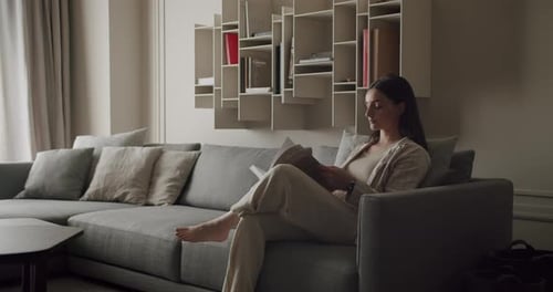Woman Reading on Sofa in Modern Living Room