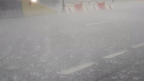 Heavy raindrop splashes on the asphalt while bad traffic.