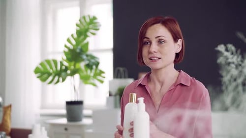 Young woman vlogger records beauty product comparison in her home studio