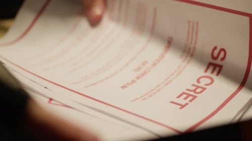 Hand Opening Briefcase to Reveal Classified Documents