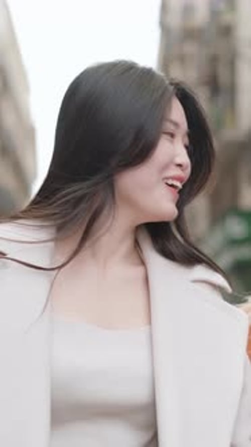 Women Chat While Strolling Through City Streets