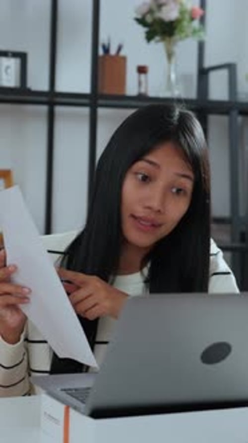 Jeune femme asiatique discute de problèmes liés au travail lors d'une réunion virtuelle à domicile