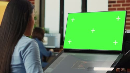 Woman Working on Green Screen Computer in Office