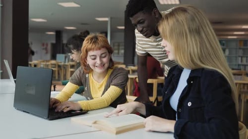 Young multiracial people studying together inside university library - School education concept