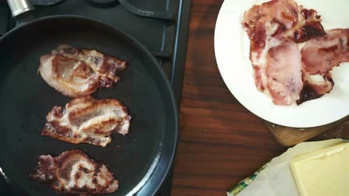 Birds Eye View of Bacon Sizzling in a Frying Pan