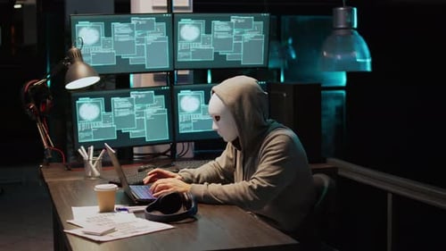 Un criminel masqué piratant un serveur informatique la nuit