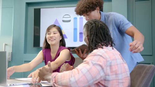 Collaborating in office, diverse team using laptop and tablet for project discussion