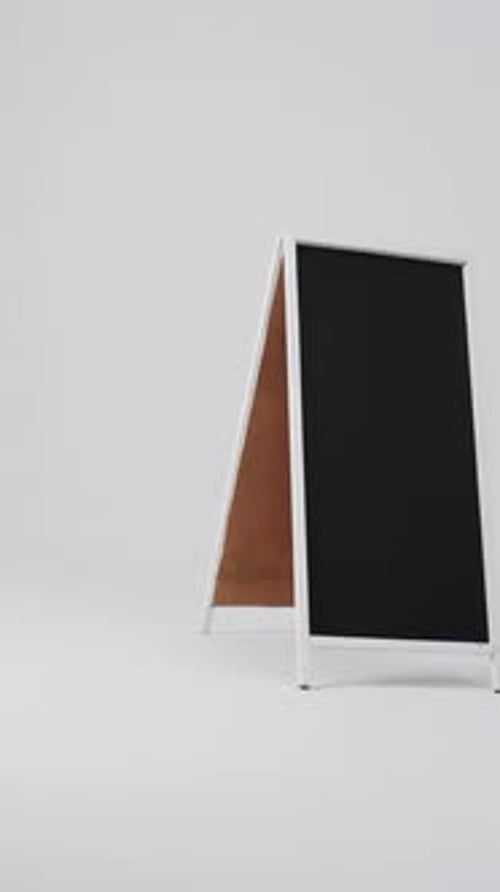 Vertical video of blackboard sign on white stand with copy space on white background