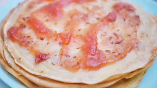As panquecas são cobertas com geleia, adicionando a aplicação de geléia rosa às panquecas francesas no prato