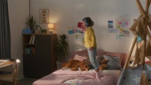 Happy Girl Dancing on Bed in Bedroom