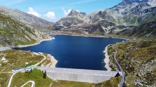 Aerial View Of Deep Blue Alpine Lake Surrounded By Mountains