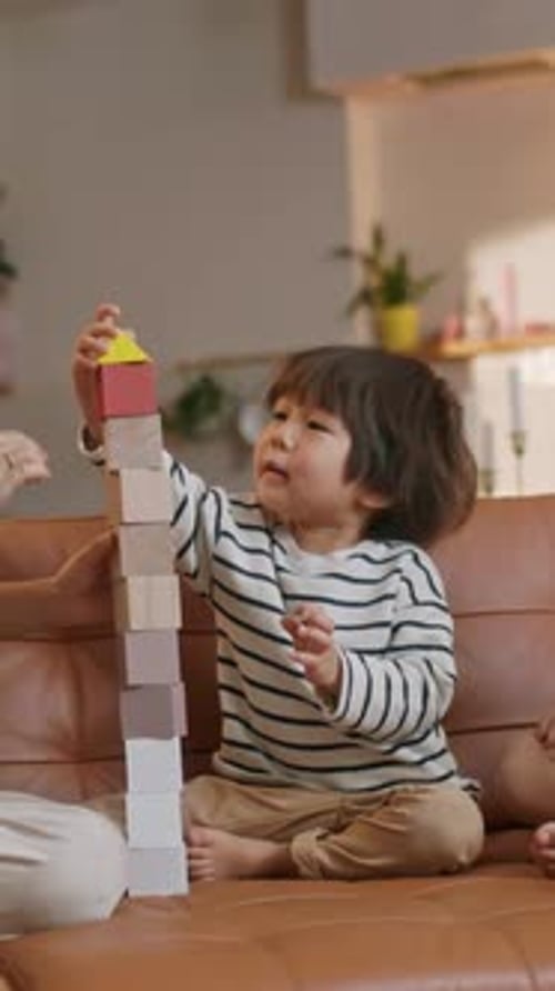 Toddler Building Wooden Block Tower with Parent at Home